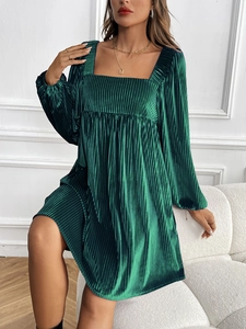 Vue détaillée de la texture du velours vert foncé et des plis fins sur la robe plissée
