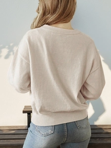 Back view of a creamy white crew neck heart sweater with ribbing detail and dropped shoulders