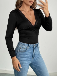 Elegant black long sleeve V-neck bodysuit with lace trim paired with blue jeans