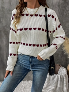 Detailed knit texture of white women sweater with red heart patterns and round neck