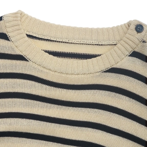 Detail of nautical stripe knit sweater with ribbed crewneck and decorative shoulder button