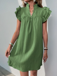 Detail view of sage green dress featuring textured pleated fabric and layered ruffle sleeves