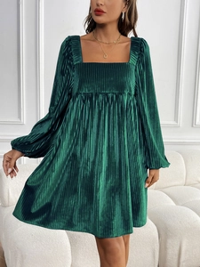 Detail of dark green velvet party dress featuring square neck and textured puff sleeves