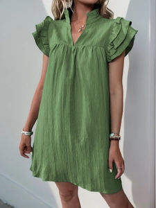 Detail of green textured dress with layered ruffle sleeves and stylish V-neck design