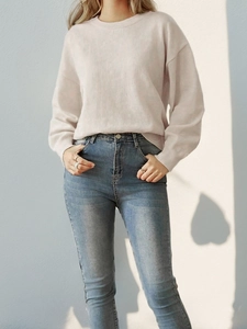 Detail of pink crewneck sweater and jeans with a creative heart-shaped light shadow