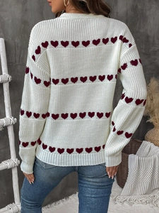 Detailed back view of a cream knit sweater with red heart patterns and ribbed cuffs