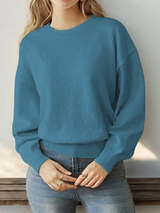 Detail of the blue heart sweater neckline and shoulder with soft natural light shadows