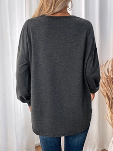 Rear view of an oversized dark grey sweatshirt featuring drop shoulders and soft knit texture