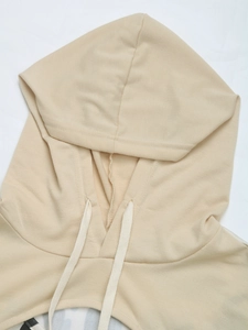 Detail shot of apricot hoodie showing drawstring hood structure and knit fabric texture
