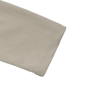 Detailed macro view of the beige waffle texture knit fabric on casual hooded shirt sleeves