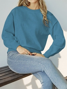 Detail of turquoise crew neck knit sweater with ribbed cuffs and drop shoulder design
