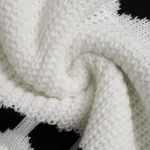 Macro shot of chunky knit sweater fabric in black and white with soft textured weave