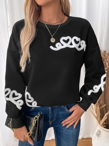 Detail of white heart towel embroidery on black crewneck sweatshirt with ribbed cuffs