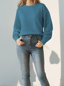 Detail showing peacock blue crew neck knitted sweater texture and soft shoulder fit