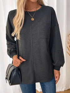 Detailed close-up of dark grey long-sleeved sweatshirt with chest pocket and lantern sleeves