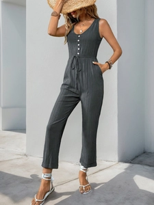 Detail of sleeveless charcoal textured jumpsuit with buttons and drawstring waist