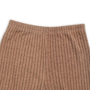 Dettaglio della vita elastica e della trama a costine verticali dei pantaloni in maglia marroni