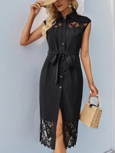 Détail d'une robe chemise noire sans manches avec dentelle et ceinture nouée