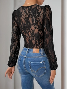 Chic black lace bodysuit with open V-back and floral embroidery paired with jeans