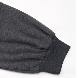 Detailed close-up of charcoal gray knitted sweatshirt featuring elastic ribbed cuffs