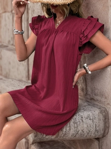 Detailed shot of burgundy textured fabric with tiered ruffle sleeves on a V-neck dress