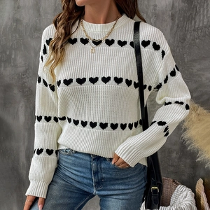 Chic white knit sweater featuring black heart patterns and ribbed crewneck design