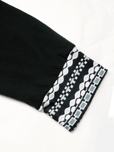 Detailed close-up of knit dress sleeve with ethnic geometric pattern and ribbed texture