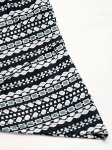 Macro detail of high-quality knit fabric featuring geometric patterns and stitched hem
