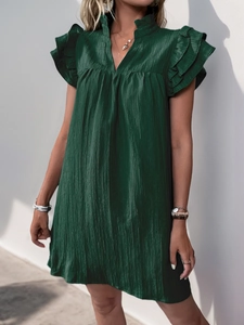 Detailed macro of dark green tiered ruffle sleeve on textured pleated dress fabric