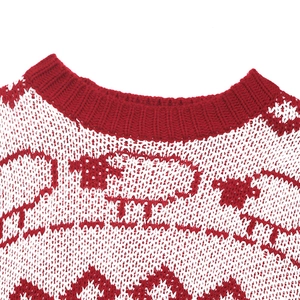 Detail showing the red ribbed crew neck and knitted sheep jacquard pattern on a holiday sweater