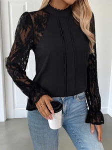 Detail of elegant black lace patchwork blouse featuring puff sleeves and ruffled cuffs