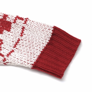 Detail of red ribbed cuffs and winter snowflake jacquard pattern on knit sweater