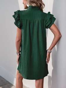 Detail of dark green dress with tiered ruffle sleeves and textured crepe fabric finish