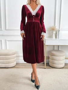 Détail d'une robe en velours bordeaux avec col en V et bordures en dentelle blanche