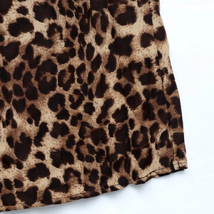 Close-up of leopard print pleated fabric showing detailed hem and texture of the skirt