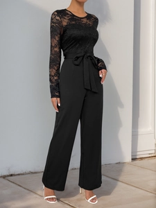Detailed view of elegant black lace long sleeves and bow belt on a jumpsuit