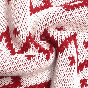 Close-up of red and white houndstooth knit fabric texture on a round neck sweater