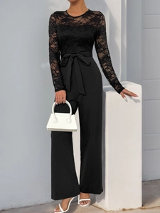 Detail of elegant black lace long sleeve jumpsuit with a stylish bow waistband
