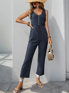 Detail view of sleeveless jumpsuits featuring textured fabric and adjustable drawstring waist