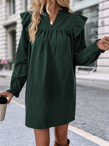Detailed view of dark green corduroy dress with ruffle shoulder and V-neckline texture