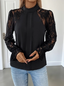 Detail of elegant black long sleeve top with lace patchwork and ruffled high neck collar
