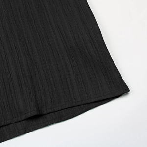 Detailed close-up of vertical pleats and hem stitching on a black summer dress