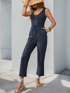 Detailed macro view of navy blue textured sleeveless jumpsuit fabric with button details