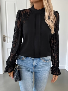 Close-up of black blouse with lace patchwork sleeves and vertical pleated chest details