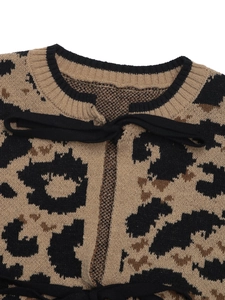 Gros plan d'un cardigan léopard avec encolure côtelée noire et détail de nœud papillon