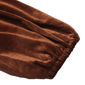 Détail de la manche d'une robe en velours marron avec poignet élastique et effet plissé