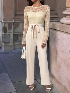 Detail of elegant lace sleeve and waist bow tie on a beige wide-leg jumpsuit