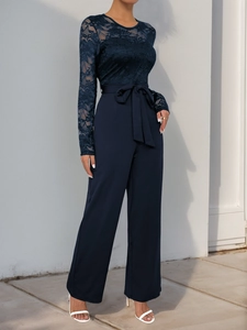 Close-up of navy blue lace splicing and bow tie waist on elegant wide-leg jumpsuit
