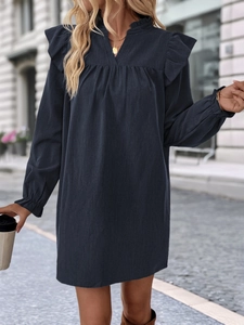 Detail of ruffled shoulders and V-neckline on a loose long-sleeve navy dress