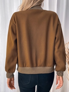 Detailed back view of camel baseball jacket with olive green ribbed collar and hem